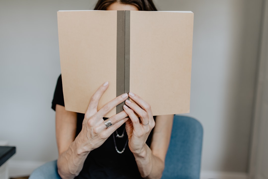 Photo by Kelly Sikkema woman in blue shirt holding white book